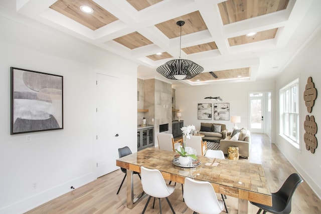 dining area featuring baseboards, coffered ceiling, and light wood-style floors