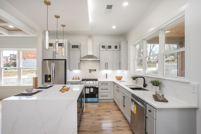 kitchen featuring wall chimney exhaust hood, glass insert cabinets, light stone counters, stainless steel appliances, and pendant lighting