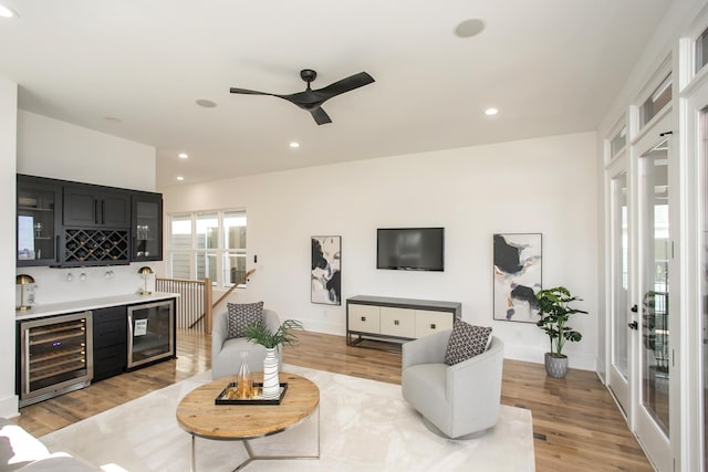 living room featuring light wood-style floors, wine cooler, indoor wet bar, and recessed lighting