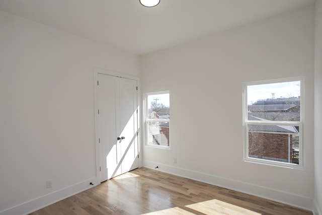 empty room with light wood-style flooring and baseboards