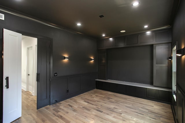 empty room with light wood-style flooring, recessed lighting, a decorative wall, visible vents, and ornamental molding