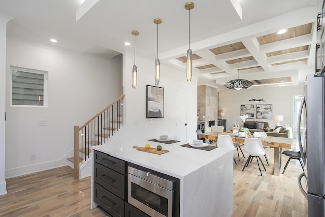 kitchen with decorative light fixtures, stainless steel appliances, open floor plan, dark cabinets, and coffered ceiling