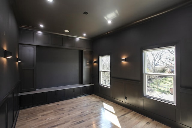 spare room with wainscoting, crown molding, light wood-type flooring, a decorative wall, and recessed lighting