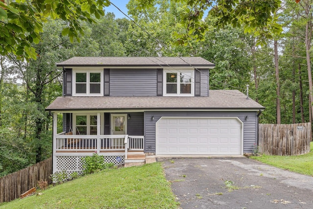 traditional home with covered porch, driveway, fence, and a garage