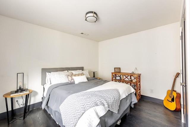 bedroom featuring baseboards, visible vents, and dark wood-type flooring