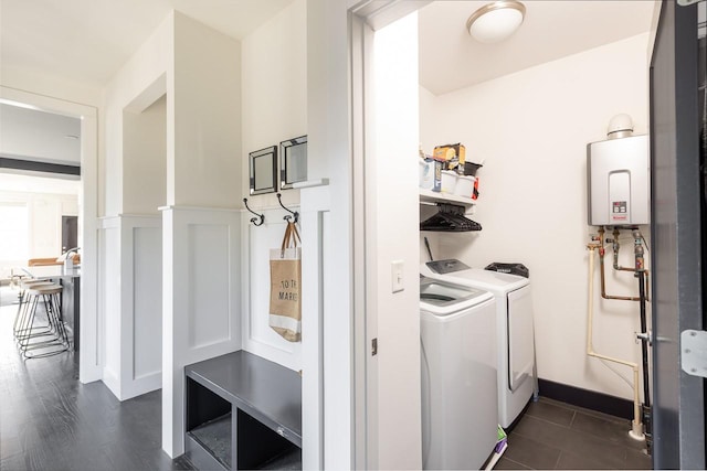 laundry room featuring a wainscoted wall, laundry area, separate washer and dryer, and tankless water heater