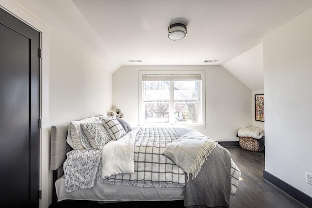 bedroom featuring lofted ceiling, dark wood finished floors, visible vents, and baseboards