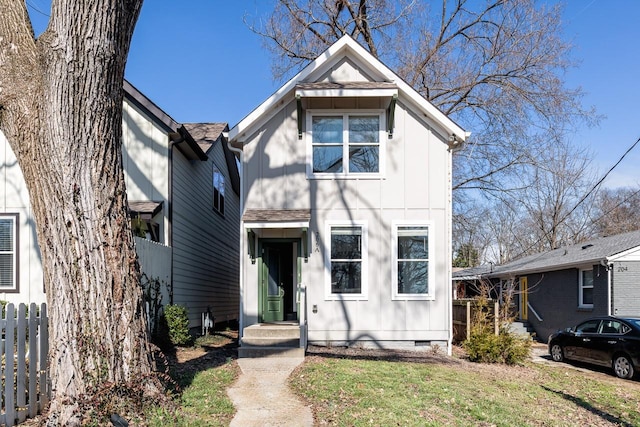 view of front of property featuring board and batten siding, crawl space, a front yard, and fence