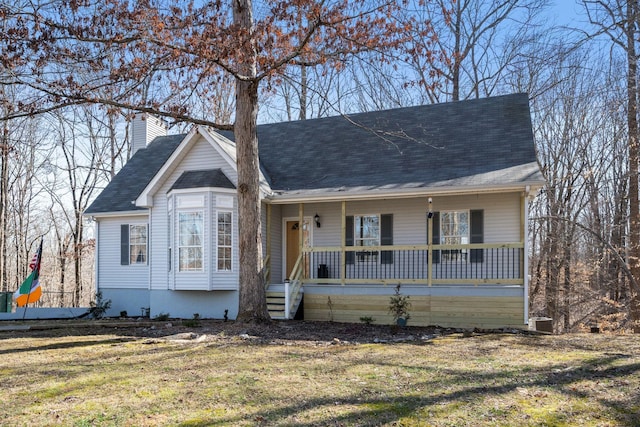 view of front of home with a porch, a front lawn, and a chimney