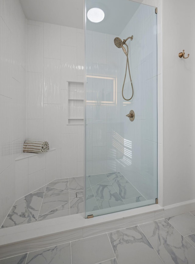 full bath with marble finish floor and a tile shower