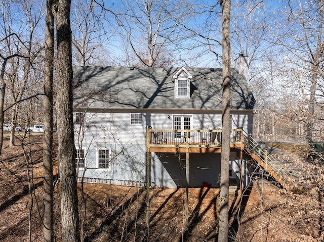 back of house with a chimney, a deck, and stairs