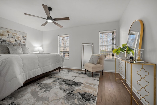 bedroom with ceiling fan, multiple windows, hardwood / wood-style flooring, and baseboards