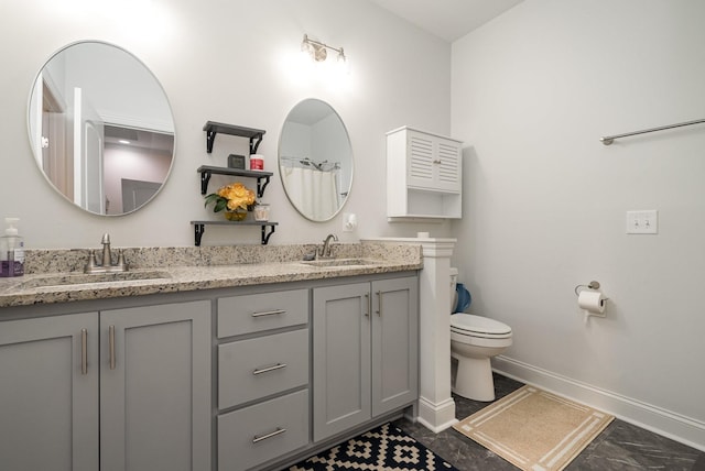 full bathroom featuring toilet, a sink, baseboards, and double vanity