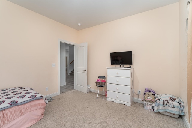 bedroom with baseboards and light colored carpet