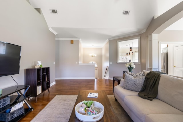 living room with baseboards, crown molding, visible vents, and wood finished floors