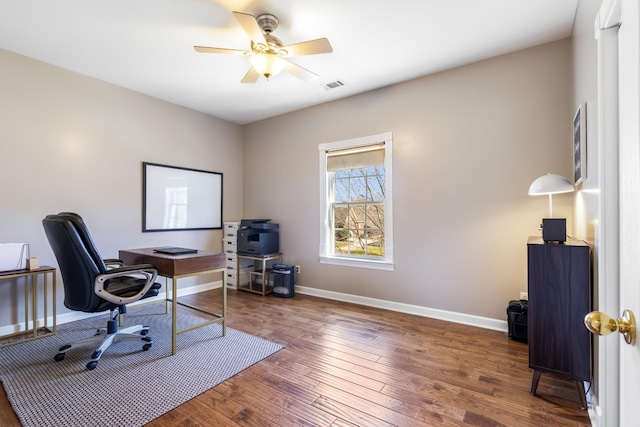 office featuring a ceiling fan, visible vents, baseboards, and hardwood / wood-style flooring