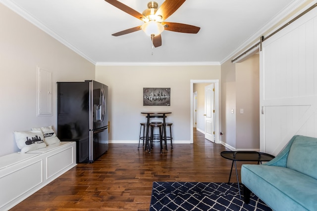 living room with a barn door, baseboards, dark wood finished floors, ceiling fan, and ornamental molding