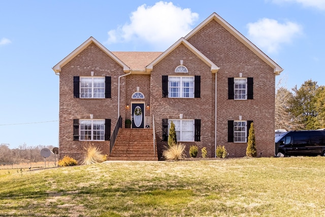 bi-level home with a front lawn and brick siding