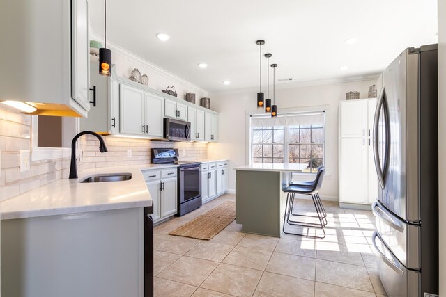 kitchen with a sink, light countertops, ornamental molding, appliances with stainless steel finishes, and tasteful backsplash