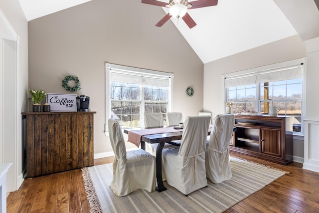 dining room with high vaulted ceiling, hardwood / wood-style flooring, and a healthy amount of sunlight