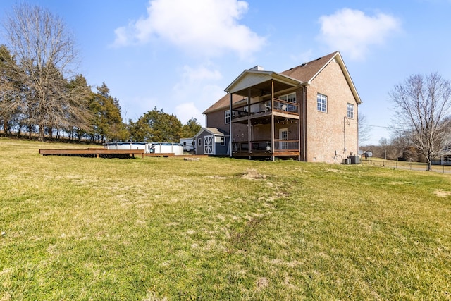 back of house with a deck, a yard, central AC, and a balcony