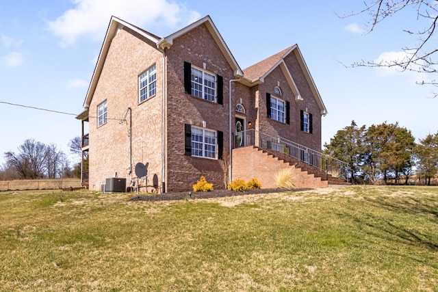 view of property exterior featuring central air condition unit, brick siding, and a yard