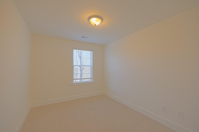 carpeted spare room with visible vents and baseboards