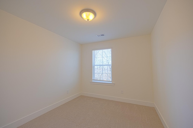 carpeted empty room featuring baseboards and visible vents