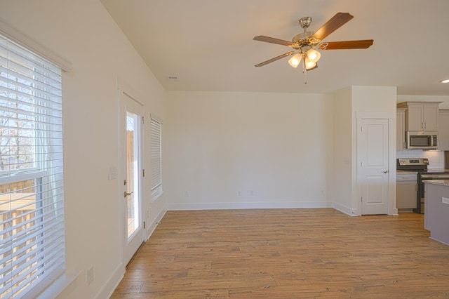 unfurnished living room with baseboards, ceiling fan, visible vents, and light wood-style floors