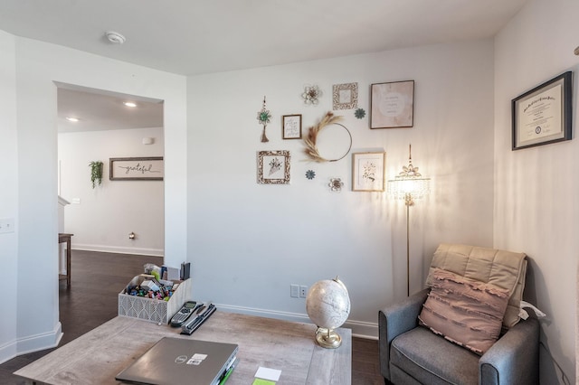 sitting room with dark wood finished floors and baseboards