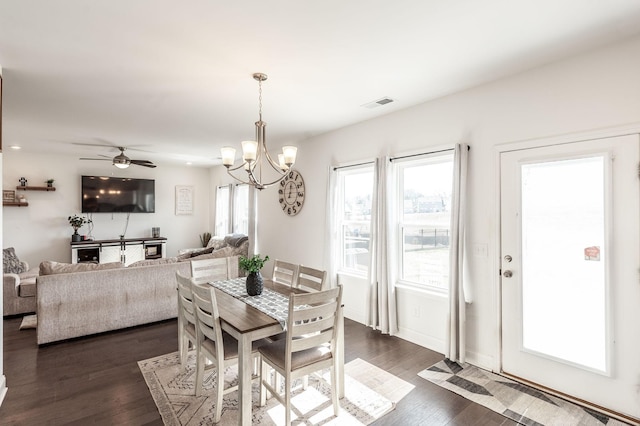 dining room featuring ceiling fan with notable chandelier, dark wood finished floors, visible vents, and baseboards