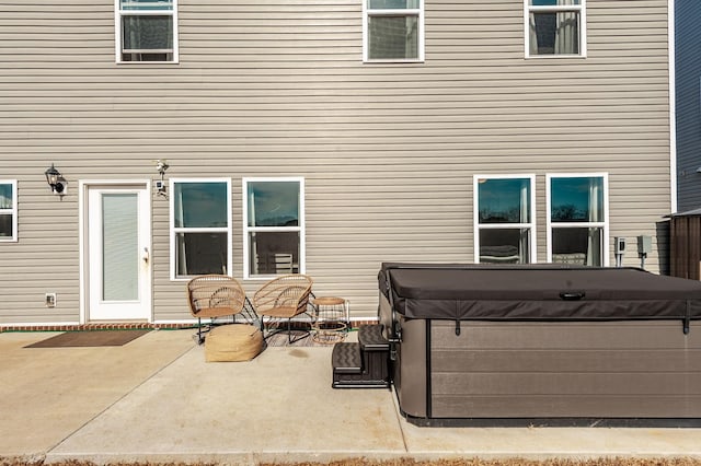 rear view of house with a patio area and a hot tub