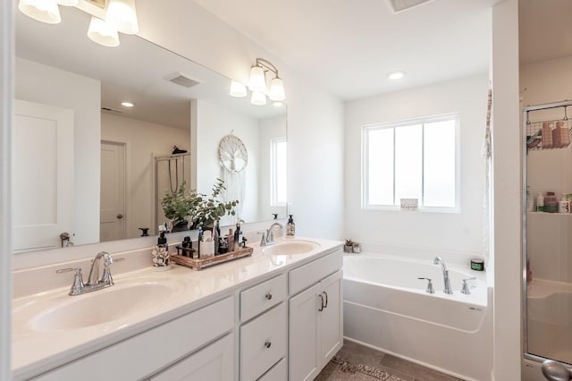 full bathroom with a bath, a shower stall, double vanity, and a sink