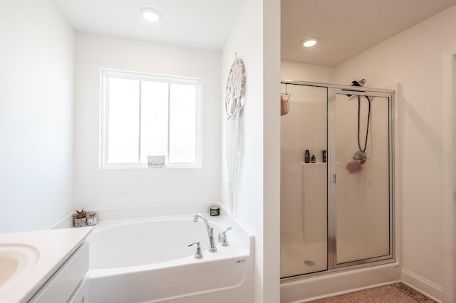 bathroom with a stall shower, recessed lighting, a bath, and vanity