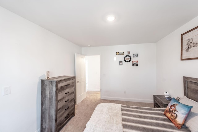 bedroom with light carpet and baseboards