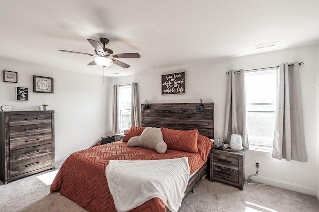 bedroom featuring ceiling fan, visible vents, baseboards, and light colored carpet