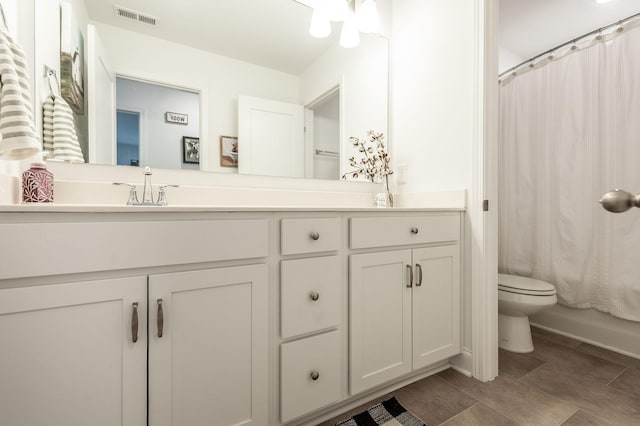 full bath with visible vents, vanity, and toilet