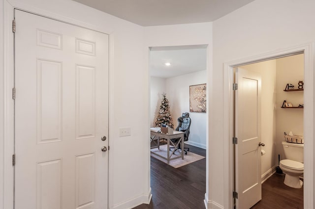 corridor featuring dark wood-style floors and baseboards