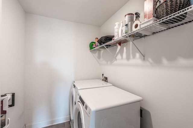 washroom with laundry area, separate washer and dryer, and baseboards