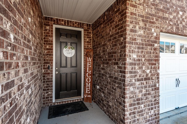 view of exterior entry with brick siding