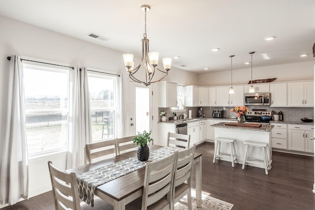 dining room with visible vents, dark wood finished floors, and a wealth of natural light