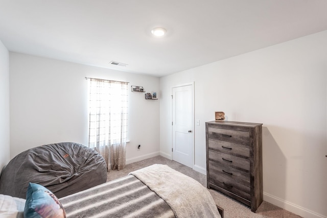 bedroom with light colored carpet, visible vents, and baseboards