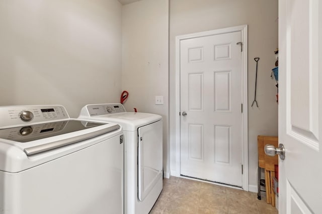 laundry area with light tile patterned floors, laundry area, and washing machine and dryer