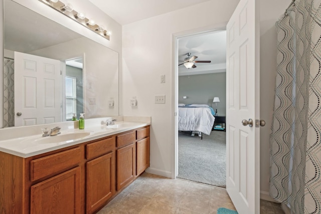 full bathroom with double vanity, ensuite bathroom, ceiling fan, a sink, and tile patterned flooring