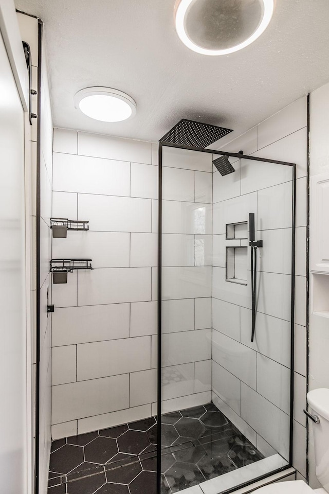 full bathroom with a stall shower and toilet