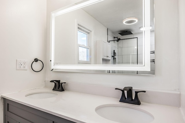 bathroom with double vanity, a shower, and a sink