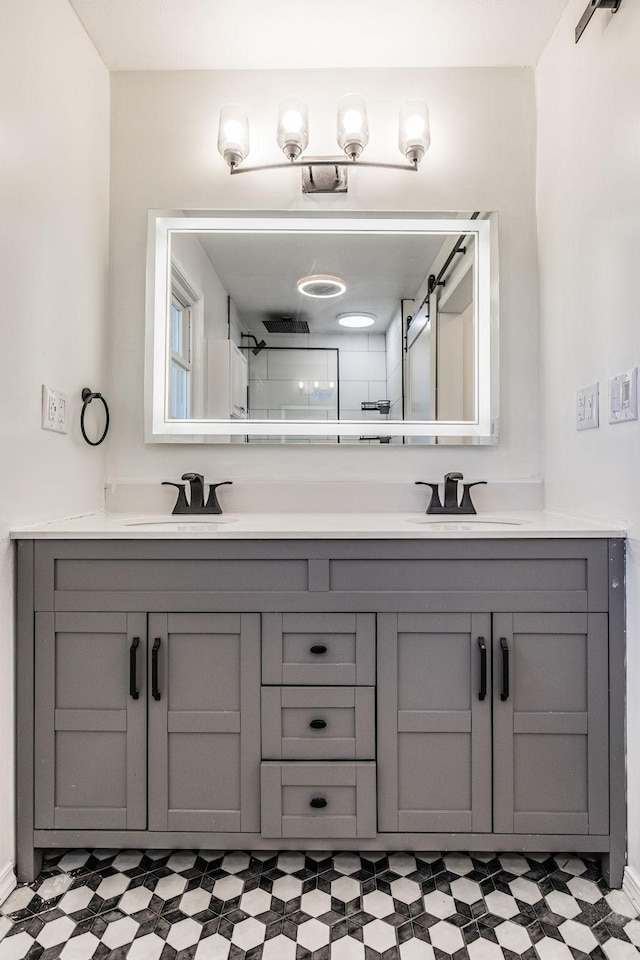 full bath featuring double vanity, a sink, and tile patterned floors