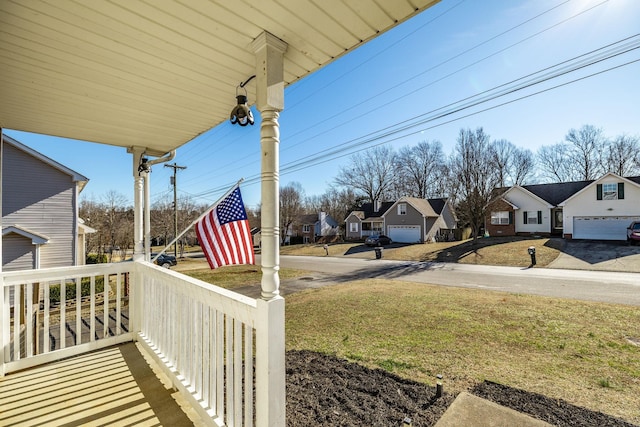 view of yard with a residential view and covered porch