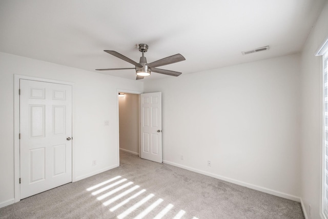 unfurnished bedroom featuring light colored carpet, visible vents, and baseboards