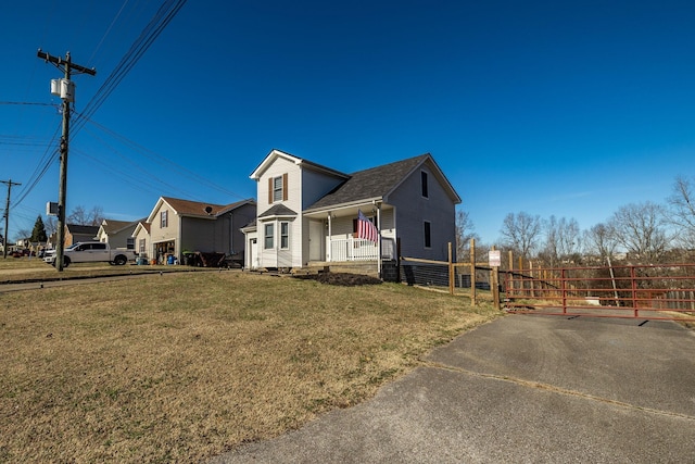 view of front of home with a front lawn, a porch, and fence